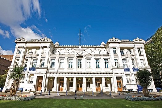 The Queen's Building on the Mile End campus on a sunny day with blue skies