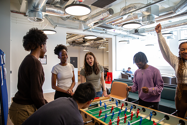 Students playing fuse ball together and laughing