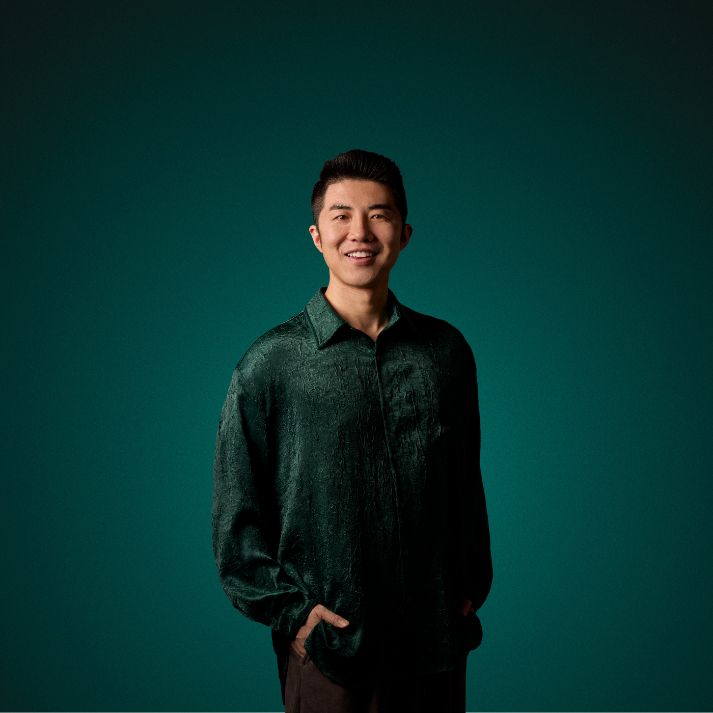 Yinglun stands in front of a green background